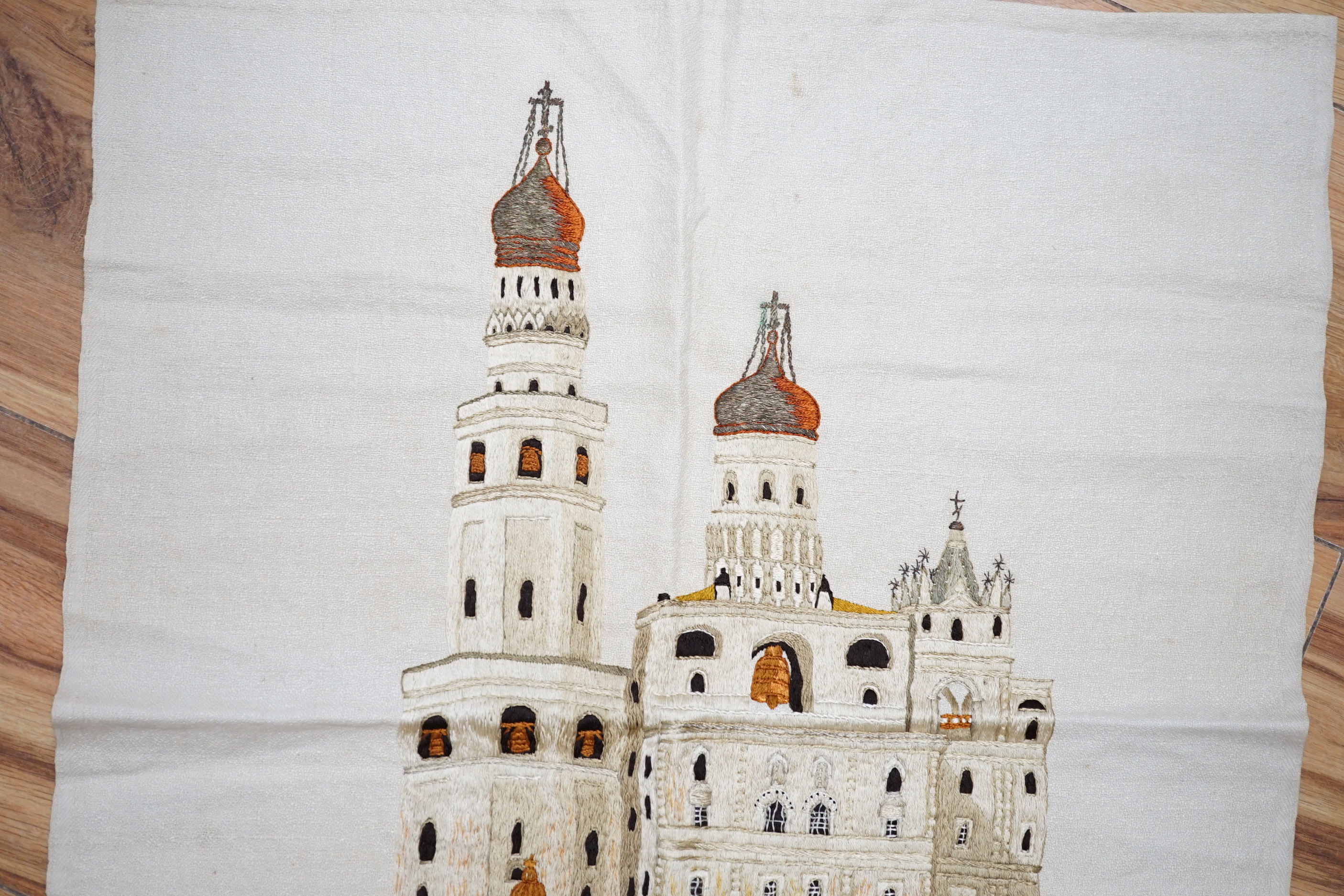 A Russian silk embroidery of a building with embroidered text below: translation ‘Ivan the Greats Belltower, The Kremlin’, 56cm high not including fringe